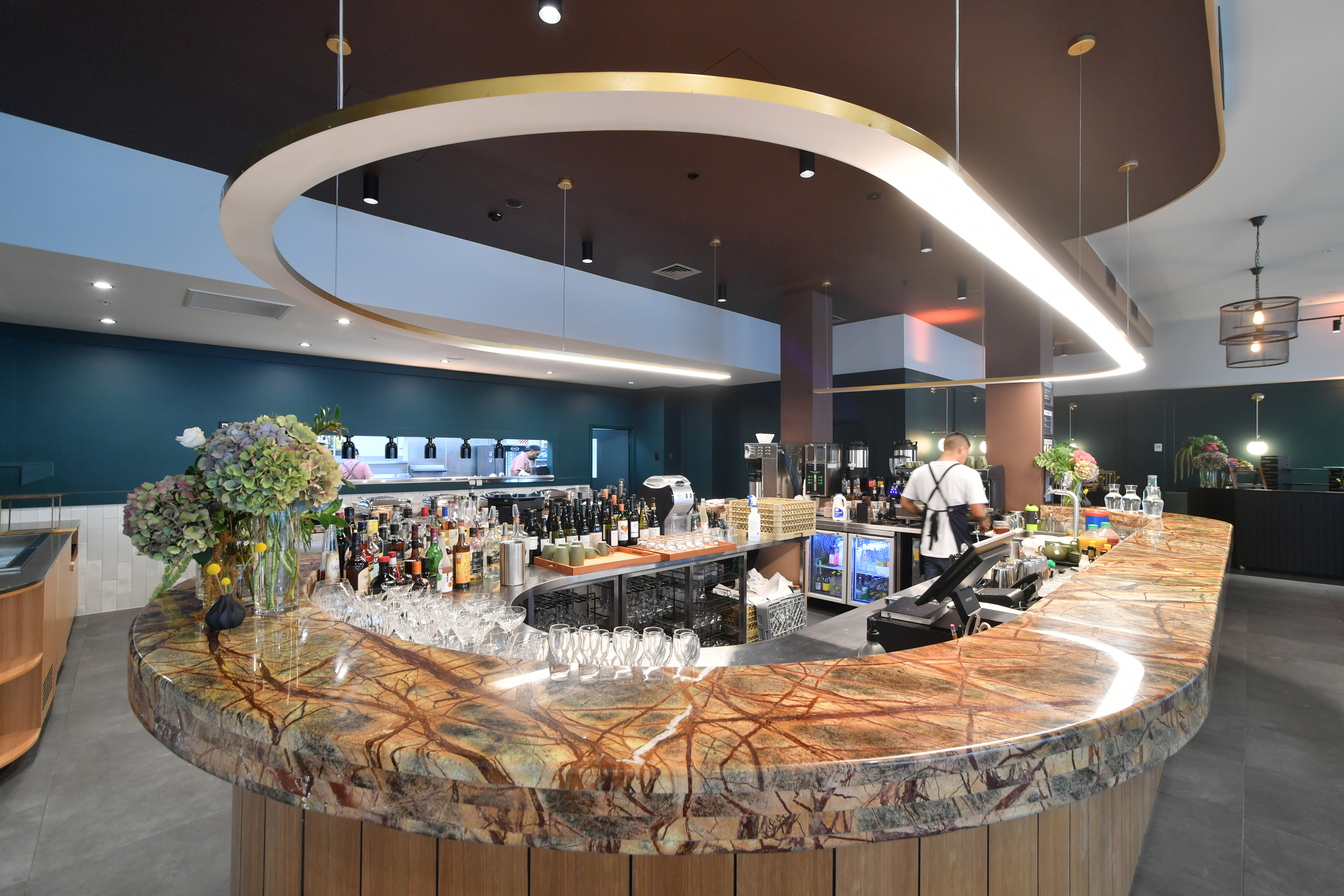 Front view of a luxurious hotel bar . A modern look bar finished with a marble countertop and ambient lighting. 